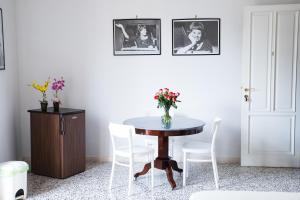a table with white chairs and a vase of flowers on it at Vittoria Guest House Battipaglia in Battipaglia