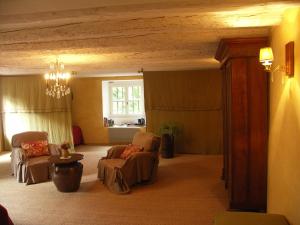 a living room with two chairs and a chandelier at Domaine du Peyron in Quintenas