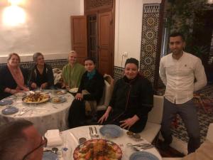 een groep mensen die rond een tafel zitten bij Dar Abdesalam in Fès