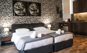 uma cama grande num quarto com uma parede de tijolos em The Athens Version Luxury Suites em Atenas