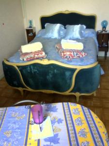 Saint-Maurice-en-GourgoisにあるChambre de la baronne de Rochegrosseのベッドルーム1室(青いベッド1台、枕、テーブル付)