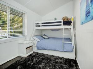 a small bedroom with a bunk bed and a window at Manning Pool House in The Entrance