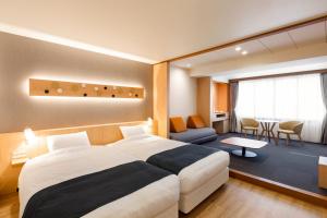 a bedroom with a large bed and a living room at Kitayuzawa Mori no soraniwa in Date