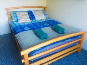 a wooden bed with pillows on it in a room at Cosy Apartment in Miltown Malbay