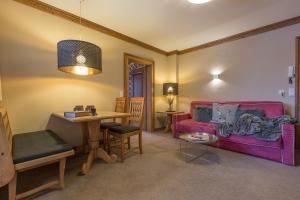 salon z czerwoną kanapą i stołem w obiekcie Villa Haidacher Relax & Lifestyle Apartments w mieście Zell am Ziller