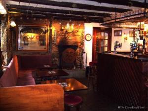 un ristorante con tavoli e un bar in una stanza di The Cross Keys Hotel a New Galloway