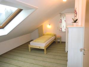 a attic bedroom with a bed and a window at Ferienwohnungen Federleicht in Titisee-Neustadt