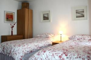 - une chambre avec deux lits et une table avec une lampe dans l'établissement The Cross Keys Hotel, à New Galloway