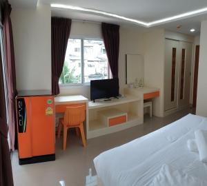 a room with a bed and a desk with a computer at The Cosy River in Bangkok