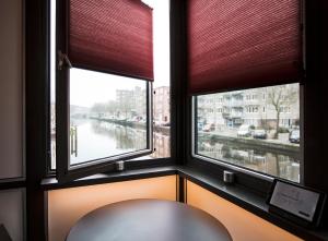 a window with a chair in a room with a view at SWEETS - Theophile de Bockbrug in Amsterdam