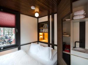 een kleine slaapkamer met een bed en een wastafel bij SWEETS - Theophile de Bockbrug in Amsterdam