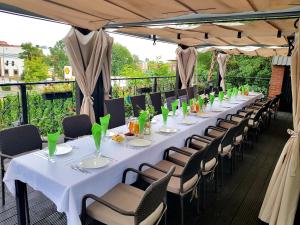 Ein langer Tisch, der für ein Abendessen auf einer Terrasse gedeckt ist in der Unterkunft Hotel Fado in Gorzów Wielkopolski