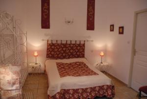 um quarto com uma cama com duas luzes na parede em La Rialhe em Taulignan
