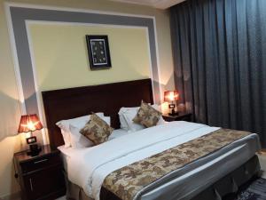 بنزرت للشقق الفندقية في الدوادمي: غرفة فندقية بسرير كبير فيها مصباحين