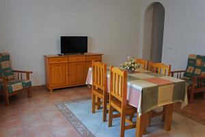 una sala da pranzo con tavolo, sedie e TV di APARTAMENTOS ALBANTA ad Alhama de Almería