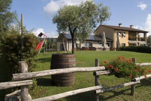 una recinzione in legno con un albero e un parco giochi di Agriturismo Moro Barel a Vittorio Veneto