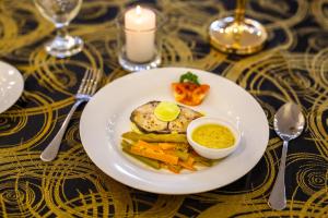 a white plate of food with vegetables on a table at Sense Pavillion in Horana