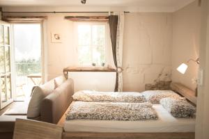 two beds in a room with a couch and a window at moments café & apartmenthaus in Thurnau
