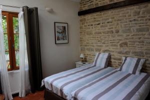1 dormitorio con 1 cama con pared de ladrillo en B&B Chez Marie, en Beaune