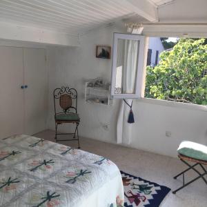 a bedroom with a bed and a window and a chair at San Ciprianu in Porto-Vecchio