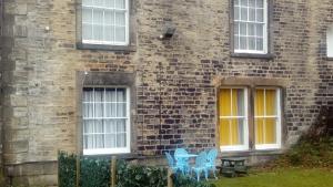 two blue chairs sitting outside of a brick building at Carer 4 You Residential Home in Upholland