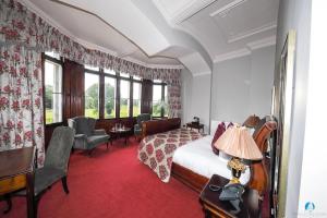 a room with a bed, chair, table and window at Markree Castle in Sligo
