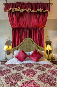 1 dormitorio con 1 cama grande y cortinas rojas en Markree Castle en Sligo