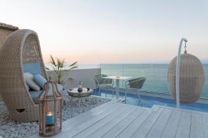 Un balcón con sillas, una mesa y el océano en Palazzo Mottola Tropea en Tropea