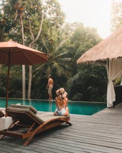 a woman and a man standing on a beach at Adiwana Resort Jembawan in Ubud