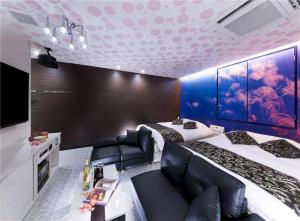 GinanにあるHOTEL SWEET SEASON-Lのベッド2台とテレビが備わるホテルルームです。