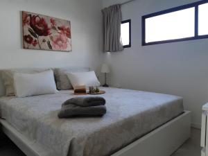Un dormitorio blanco con una cama con una manta. en Heliopolis, en San Agustín 17 fotos más