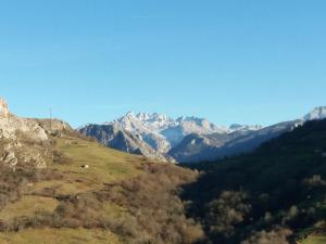 a mountain range with snow capped mountains in the distance at La Cabaña del Beyu Pen in Amieva
