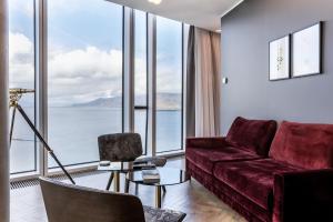 a living room with a red couch and large windows at Tower Suites Reykjavík in Reykjavík