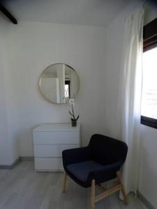 Zimmer mit einem blauen Stuhl und einem Spiegel in der Unterkunft ÁTICO PTA 13 EN EL CENTRO DE VALENCIA VT-45727-T in Valencia