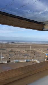 a view of a beach from a window at Les Embruns in Trouville-sur-Mer