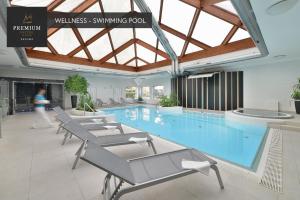 兹诺伊莫PREMIUM Wellness & Wine Hotel Znojmo的建筑物内设有带椅子的大型游泳池