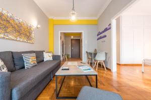 ein Wohnzimmer mit einem Sofa und einem Tisch in der Unterkunft Athens Boutique Apartment by Cloudkeys in Athen