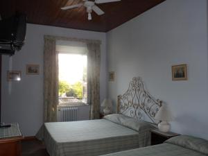 una camera da letto con due letti e una finestra di Albergo Lucia Pagnanelli a Castel Gandolfo Altre 27 foto