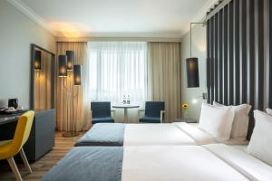 a hotel room with a large bed and a desk at HF Ipanema Park in Porto