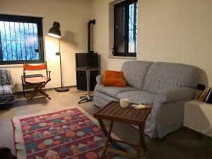 ein Wohnzimmer mit einem Sofa und einem Tisch in der Unterkunft La tana del riccio in San Sisto dei Valdesi