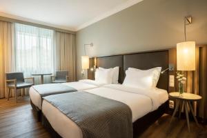 a hotel room with two beds and a table at HF Ipanema Park in Porto
