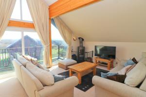 a living room with two couches and a television at ON-SITE WATERSPORTS luxury lodge in Saint Columb Major