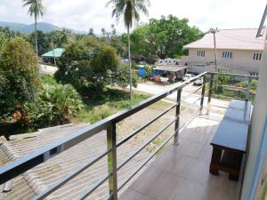 a balcony with a bench and a view of a street at EQ Hostel in Thongsala