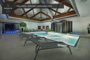 einen Pool in einem Gebäude mit Stühlen um ihn herum in der Unterkunft PREMIUM Wellness & Wine Hotel Znojmo in Znojmo