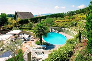 a swimming pool in a garden with chairs and a table at Hotel Blanc in Marigny-Saint-Marcel