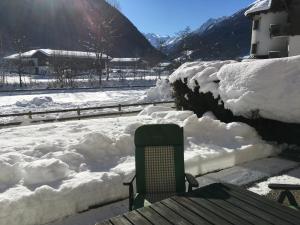 une pile de neige à côté d'une table avec un banc dans l'établissement Ferienwohnung Scheibe, à Neustift im Stubaital