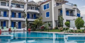 a hotel with a swimming pool in front of a building at Limni Hotel in Fanari