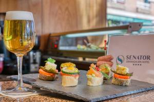 a tray with sandwiches and a glass of wine at Senator Granada Spa Hotel in Granada