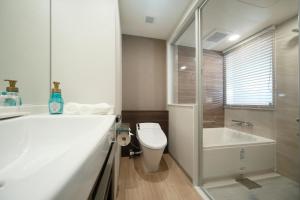a bathroom with a toilet and a sink and a tub at Miyako City Tokyo Takanawa in Tokyo