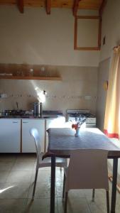 a kitchen with a table and chairs in a room at Montalto in Dina Huapi
